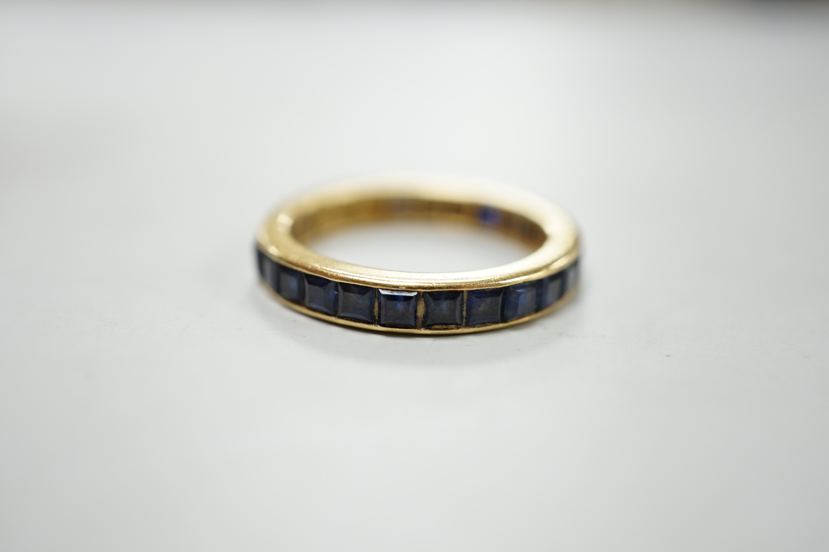 A yellow metal and sapphire set full eternity ring, size R, gross weight 4.6 grams.